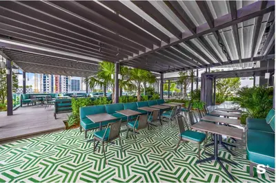 a patio with tables and chairs and palm trees at Upscale 1-BD Condo in DTW Miami - City Views in Miami
