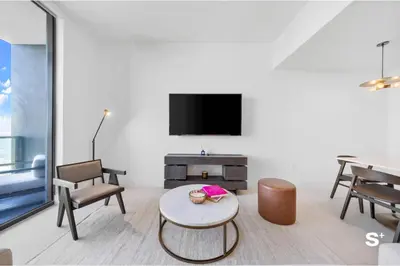 a living room with a table and a tv at Luxury 1-BD with Breathtaking Downtown Views in Miami