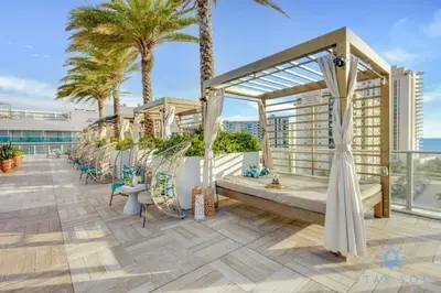 a balcony with chairs and palm trees on a building at Miami Escape Views & Amenities in Hollywood