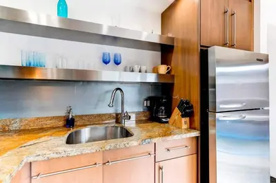 a kitchen with a sink and a stainless steel refrigerator at Entire townhouse Ft Lauderdale in Fort Lauderdale
