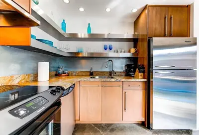 a kitchen with wooden cabinets and a stainless steel refrigerator at Entire townhouse Ft Lauderdale in Fort Lauderdale