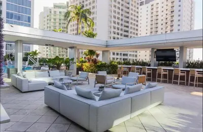 a patio with white couches and a television and buildings at Brickell-AKA Free Parking by Palermo Home Miami in Miami