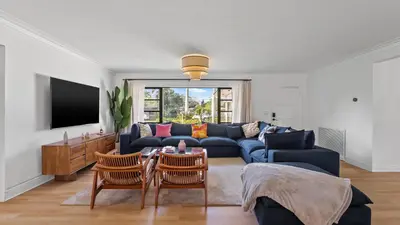 a living room with a blue couch and a table at Luxury Miami Waterfront Retreat with Private Dock in Golden Glades