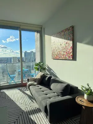 a living room with a couch and a large window at Elevated Elegance Luxe View Pool Free Parking in Miami