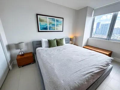 a white bedroom with a large bed and a window at Luxury 3 bedroom condo with pool in Hallandale Beach