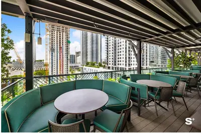 a balcony with tables and chairs and a view of a city at Modern Studio in Downtown Miami with Stunning City Views in Miami