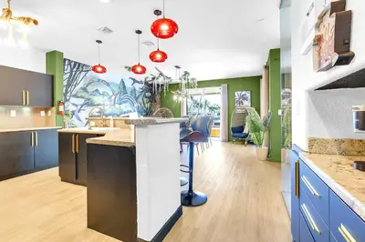 a kitchen with blue and green walls and a counter at Luxury Glow Villa Miami - 4K Private Cinema, Heated Pool & Spa, Game Room - 5BR Lakefront Estate for 12 Guests in Hammocks