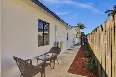 a patio with chairs and a table next to a fence at Serene Suite Near Aventura in Ives Estates
