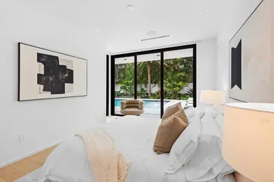 a white bedroom with a bed and a window at Luxury 6-Bedroom Villa stunning 3-story estate in Golden Beach