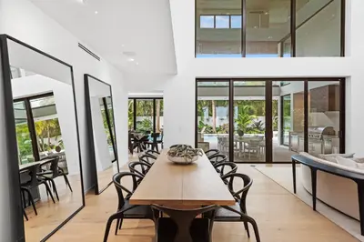 a dining room with a wooden table and chairs at Luxury 6-Bedroom Villa stunning 3-story estate in Golden Beach