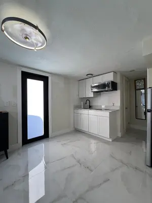 a large kitchen with white cabinets and a window at AMIRI Hollywood 5 mins from Hard Rock Stadium & The Guitar in Hollywood