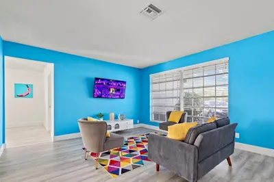 a living room with blue walls and a couch and chairs at Pool, golf & 4 mi. from the beach & The Hard Rock in Hollywood