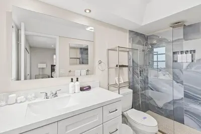 a white bathroom with a sink and a shower at Beach, Pool & Las Olas Getaway in Fort Lauderdale