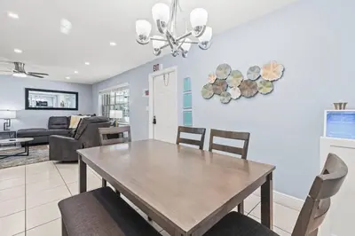 a dining room and living room with a table and chairs at Beach, Pool & Las Olas Getaway in Fort Lauderdale