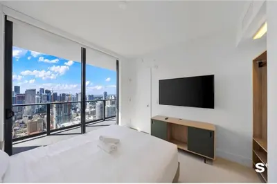 a white bedroom with a large white bed and a large window at City Luxe Retreat Modern 2-BD with Water Views in Miami