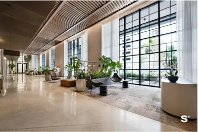a lobby with potted plants and large windows at City Luxe Retreat Modern 2-BD with Water Views in Miami