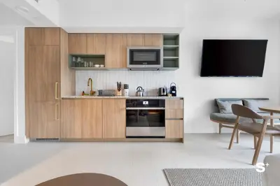 a living room with a kitchen with a microwave and a tv at Studio in DTW Miami - City Views & Gym in Miami