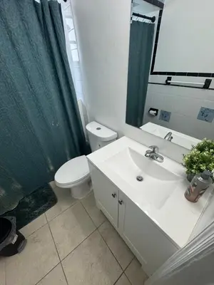 a bathroom with a sink and a toilet and a mirror at Pacifica Fort Lauderdale Airport in Dania Beach