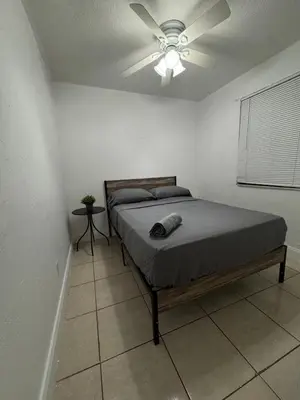 a bedroom with a bed with a ceiling fan at Pacifica Fort Lauderdale Airport in Dania Beach