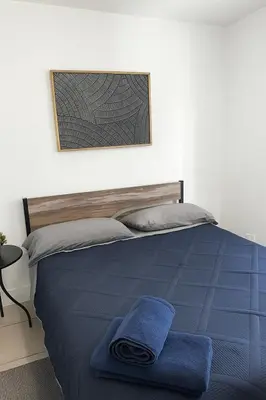 a bedroom with a bed with a blue blanket at Pacifica Fort Lauderdale Airport in Dania Beach
