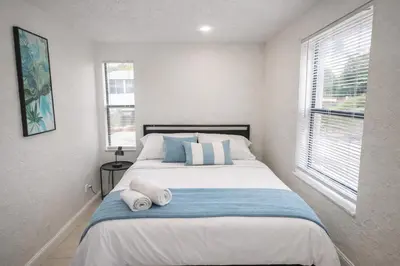 a bedroom with a large bed with towels on it at Pacifica Fort Lauderdale Airport in Dania Beach