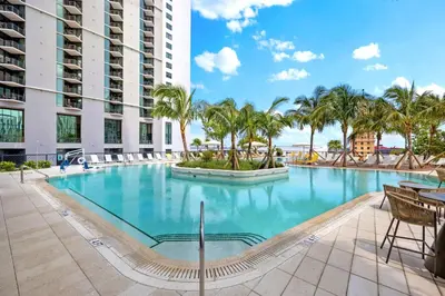 a large swimming pool with palm trees in a building at From 43th Floor a Luxury Condo Awaits For You! in Miami