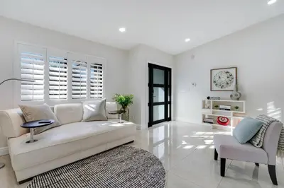 a white living room with a white couch and a chair at Casa Brisa - Stylish BBQ Near heart of Kendall in Miami