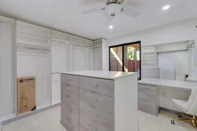 a white kitchen with a desk and a chair at Casa Brisa - Stylish BBQ Near heart of Kendall in Miami