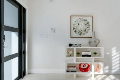 a white living room with a picture on the wall at Casa Brisa - Stylish BBQ Near heart of Kendall in Miami