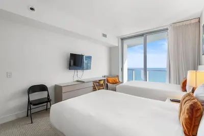 a hotel room with two beds and a television at City Lights and Skyline Nights - High-Floor Stay in our Luxury Apartment in Hollywood