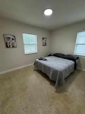 a bedroom with a bed in a room with two windows at The Awali in Miami