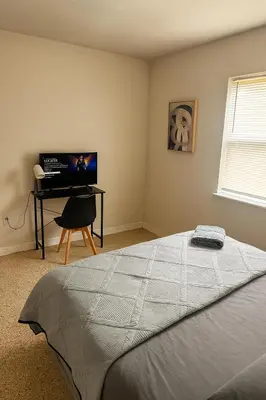 a bedroom with a bed and a desk with a television at The Awali in Miami