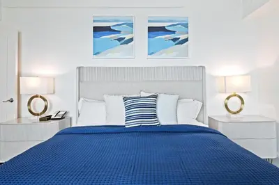 a bedroom with a blue bed with two lamps at Ritz-Carlton Luxury Oceanfront 2BR on 16th Floor in Fort Lauderdale