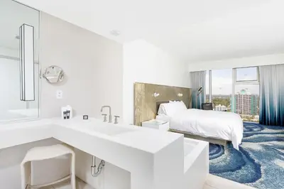a white hotel room with a bed and a sink at 16th Floor Luxury 2 Bedroom - Ocean Views & Luxury in Fort Lauderdale