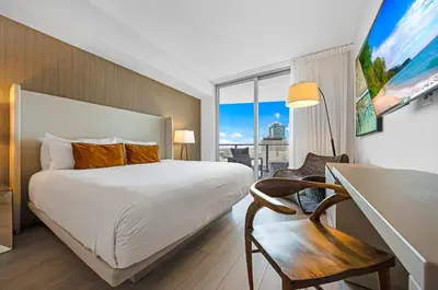 a hotel room with a bed and a desk with a chair at High-End Apartment in a Luxury Resort with Gorgeous Amenities in Hollywood