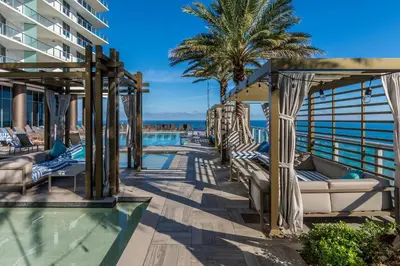 a resort pool with lounge chairs and palm trees at High-End Apartment in a Luxury Resort with Gorgeous Amenities in Hollywood