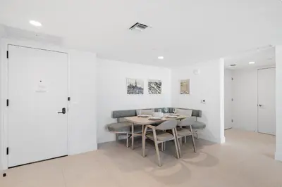 a dining room with white walls and a table and chairs at Luxury 2-Bdrm Condo in the Heart of Downtown Miami in Miami