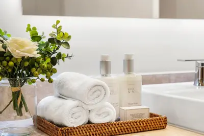 a basket of towels and a vase of flowers in a bathroom at 1 Bedroom Private Residence at Roney Palace -1129 in Miami Beach