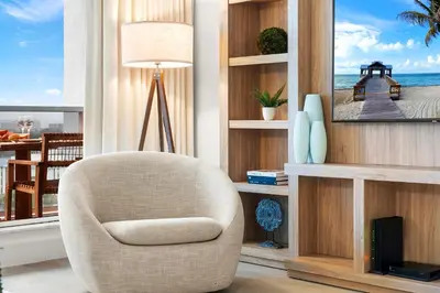 a living room with a chair in front of a window at 1 Bedroom Private Residence at Roney Palace -1129 in Miami Beach