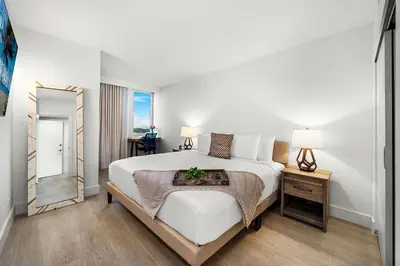 a bedroom with a large white bed and a mirror at 1 Bedroom Private Residence at Roney Palace -1129 in Miami Beach