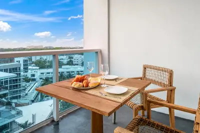 a table with a plate of bread and wine glasses on a balcony at 1 Bedroom Private Residence at Roney Palace -1129 in Miami Beach