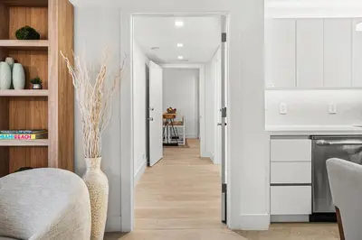 a living room with a vase and a kitchen at 2 Bedroom Private Residence at Roney Palace -11289 in Miami Beach