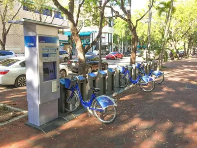 a row of bikes parked next to a parking meter at Cocktails & Coffee with bay & city view balconies in Miami