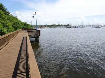a wooden pier with boats in the water at Cocktails & Coffee with bay & city view balconies in Miami