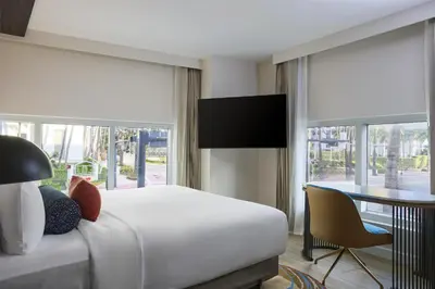 a hotel room with a bed and a desk and window at Hyatt Centric South Beach Miami in Miami Beach