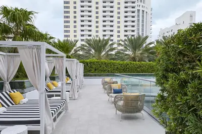 a hotel patio with lounge chairs and a pool at Hyatt Centric South Beach Miami in Miami Beach