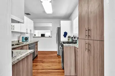 a large kitchen with wooden cabinets and a counter top at Dream Hollywood Beach Retreat With Jacuzzi and Fire Pit in Dania Beach
