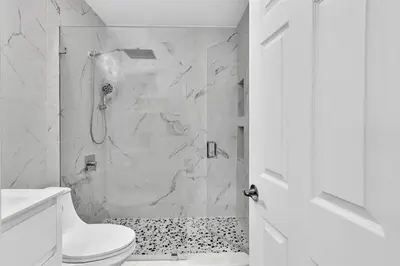 a white bathroom with a shower and a toilet at Dream Hollywood Beach Retreat With Jacuzzi and Fire Pit in Dania Beach