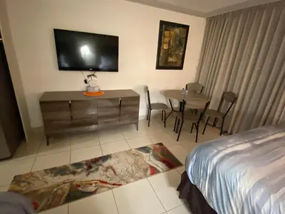 a hotel room with a bed and a tv and a table at All you need around you in Sunny Isles Beach