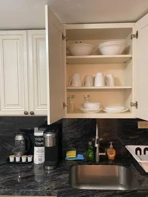 a kitchen counter with a sink and white cabinets at All you need around you in Sunny Isles Beach
